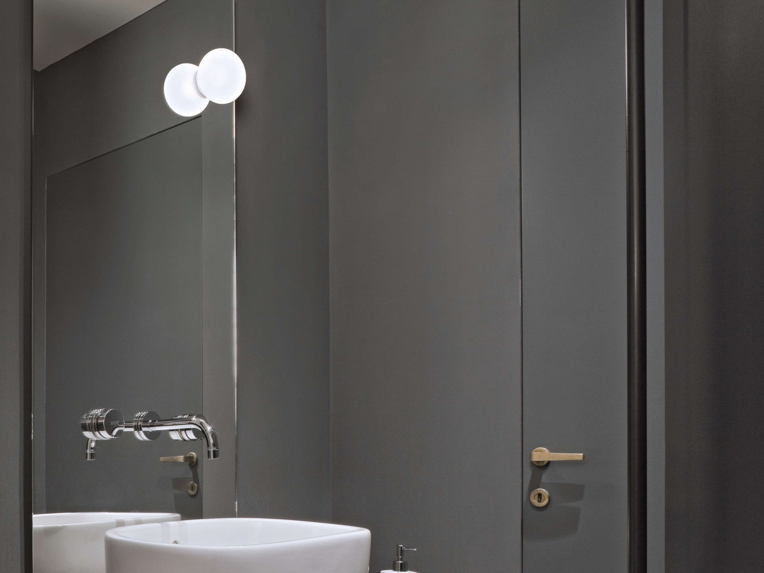 Mini Glo Ball vegglampe fra Flos på bad montert på speil