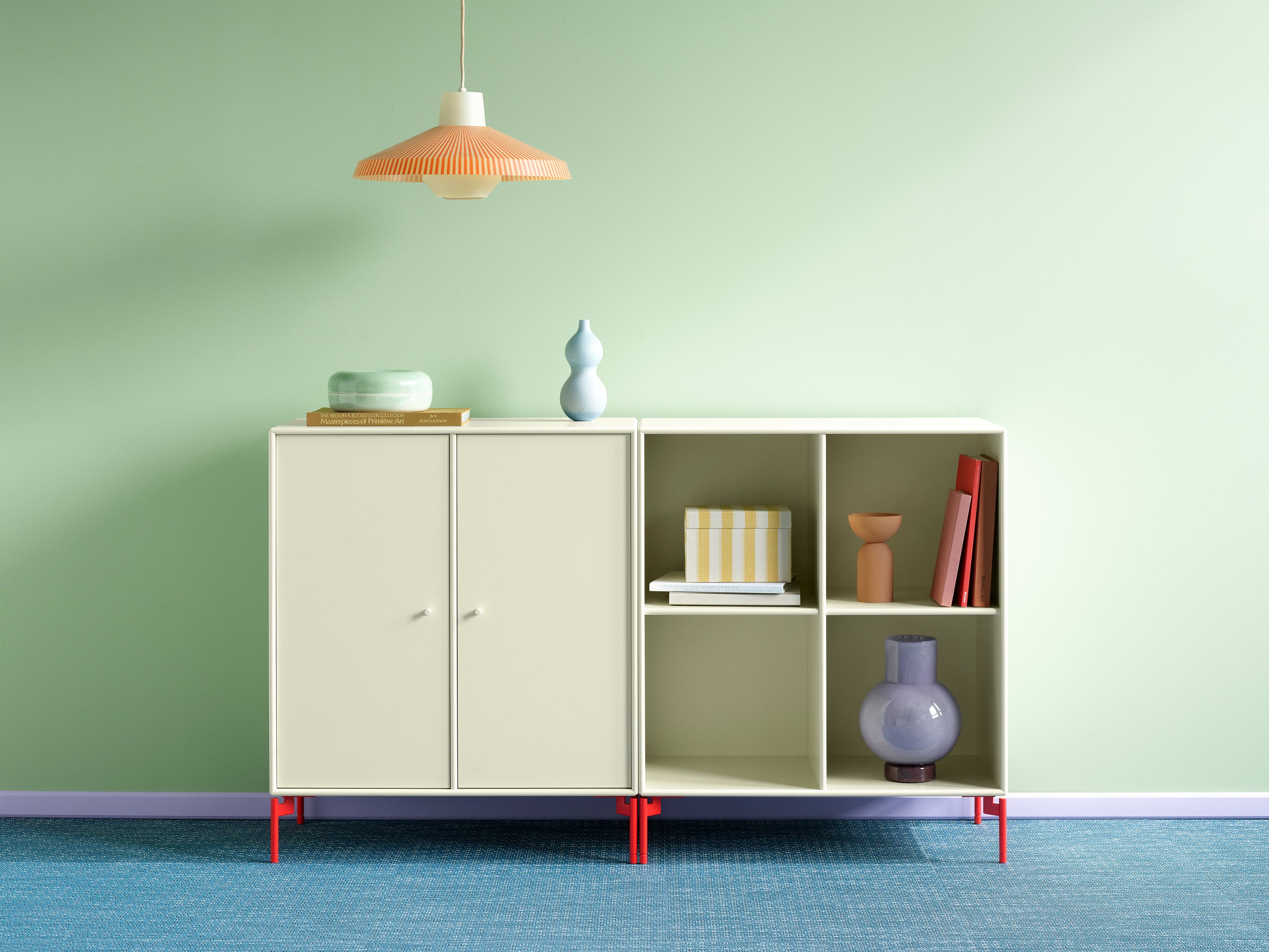 Montana PAIR Sideboard i lys fargetone med røde ben, vist i skandinavisk stue med grafisk uttrykk.