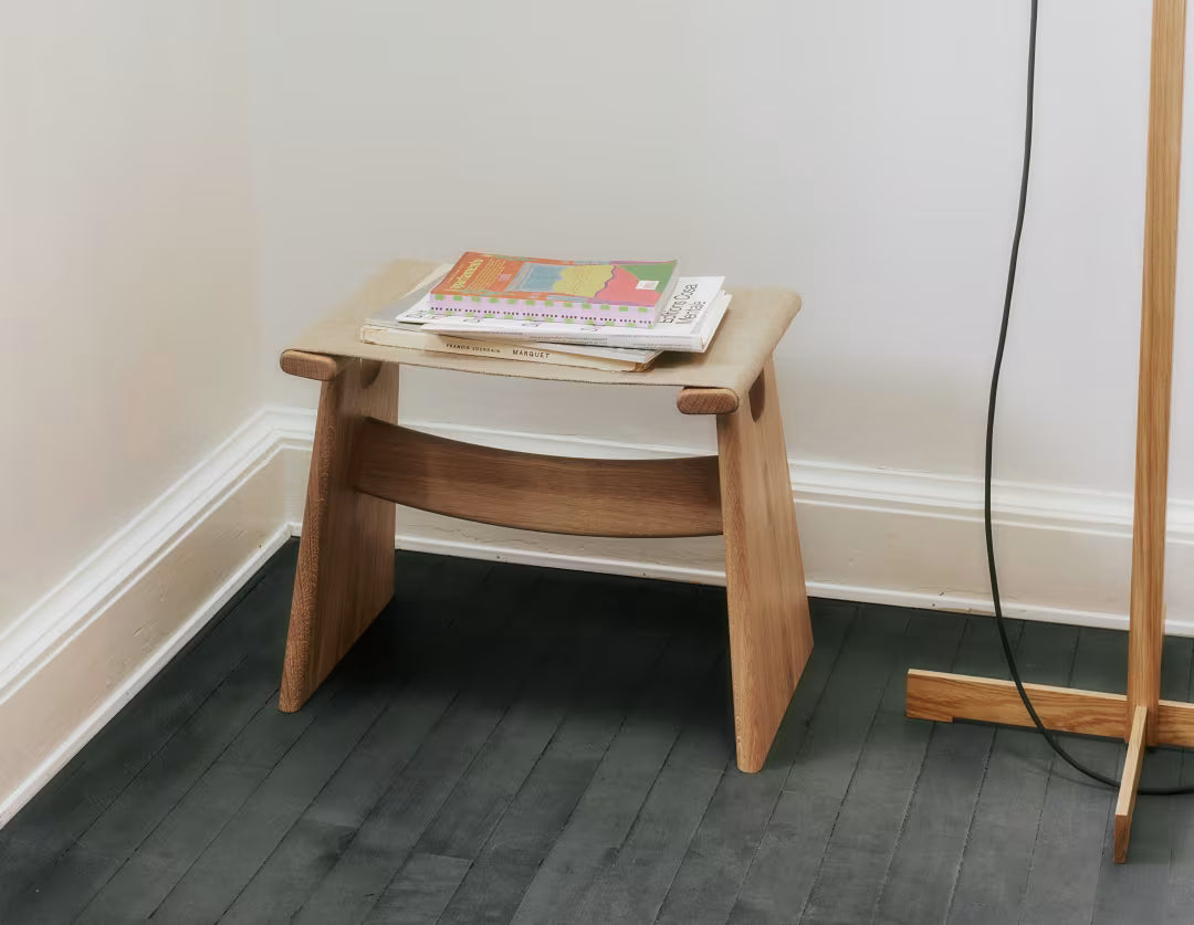 Seto Stool i lysoljet eik med naturcanvas plassert ved siden av TMM-lampe fra Santa & Cole, i et moderne interiør, viser krakkens tidløse design og elegante samspill med belysning.