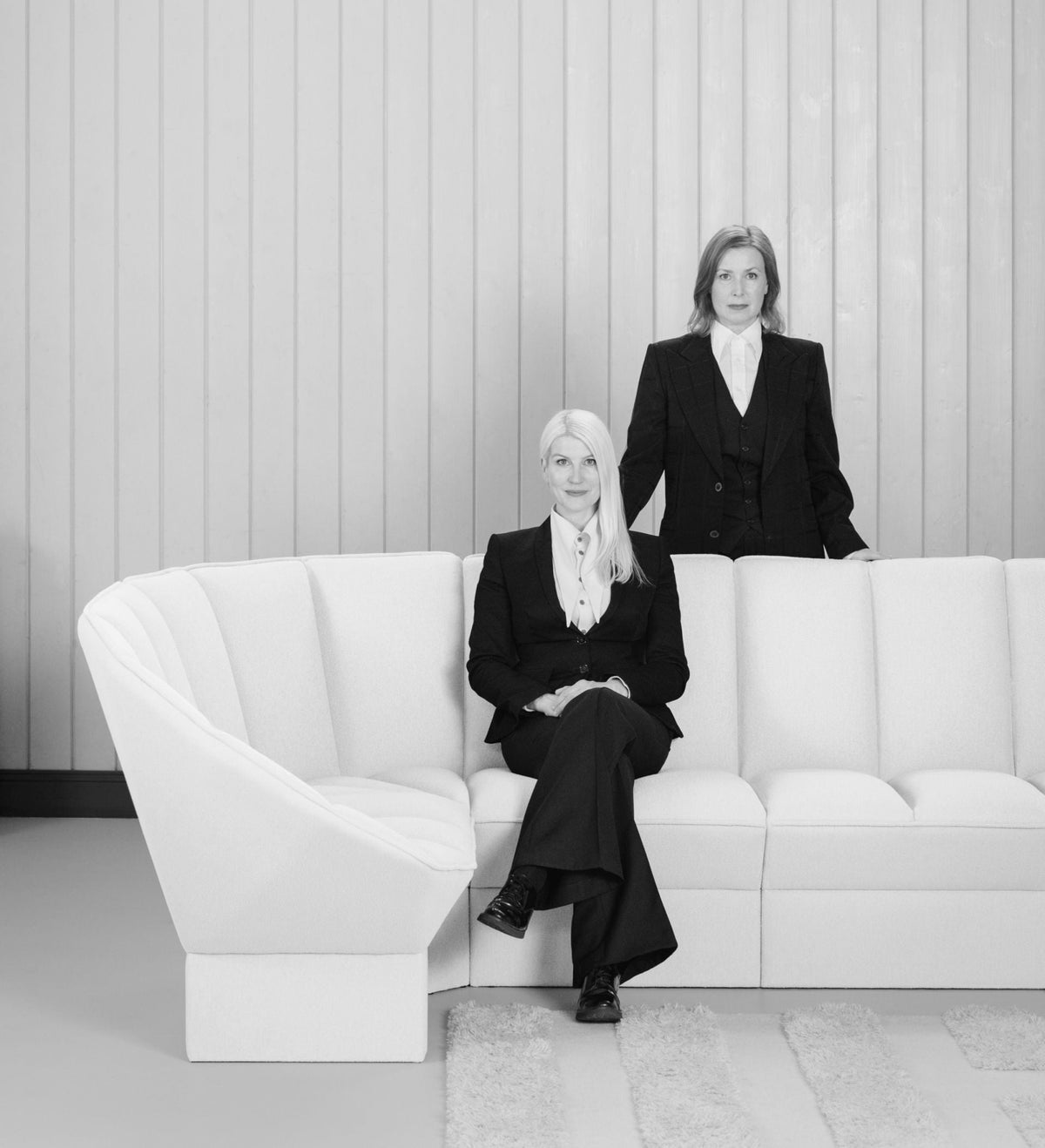 Portrett av designerne i FRONT ved en hvit sofa