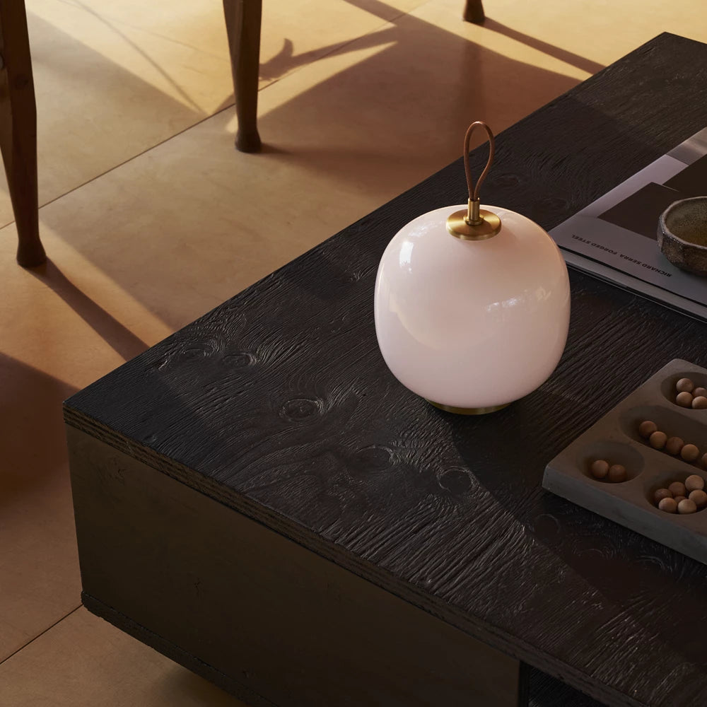 Vl 45 Portable oppladbar lampe fra Louis Poulsen med rosa glass på sort stuebord 