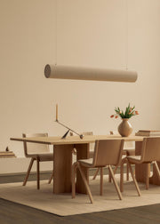 Hashira Linear Taklampe fra Audo Copenhagen over Androgyne Spisebord i eik
