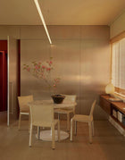 Cassina CAB Spisestol i lyst skinn rundt spisebord i marmor, Akari bordlampe på hylle