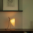 Classic Accent bordlampe av Joe Armitage plassert på en hylle med lys på