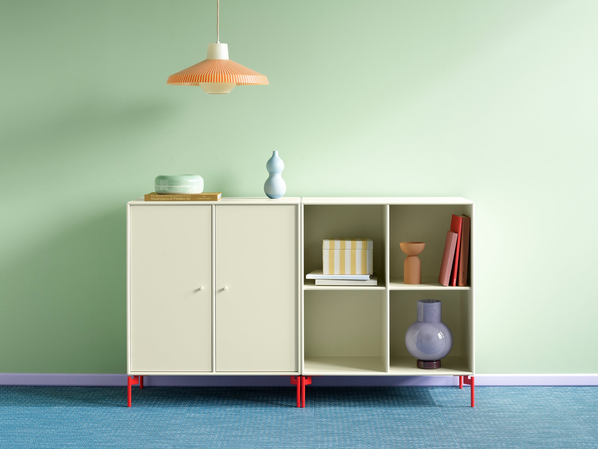 Montana PAIR Sideboard i lys fargetone med røde ben, vist i skandinavisk stue med grafisk uttrykk.