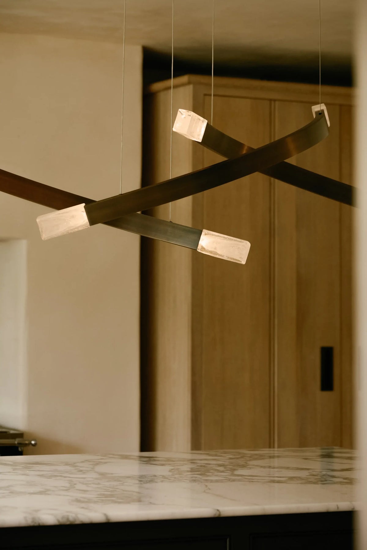 Trace Linear Pendel fra CTO Lighting med glasskjermer og buede armer