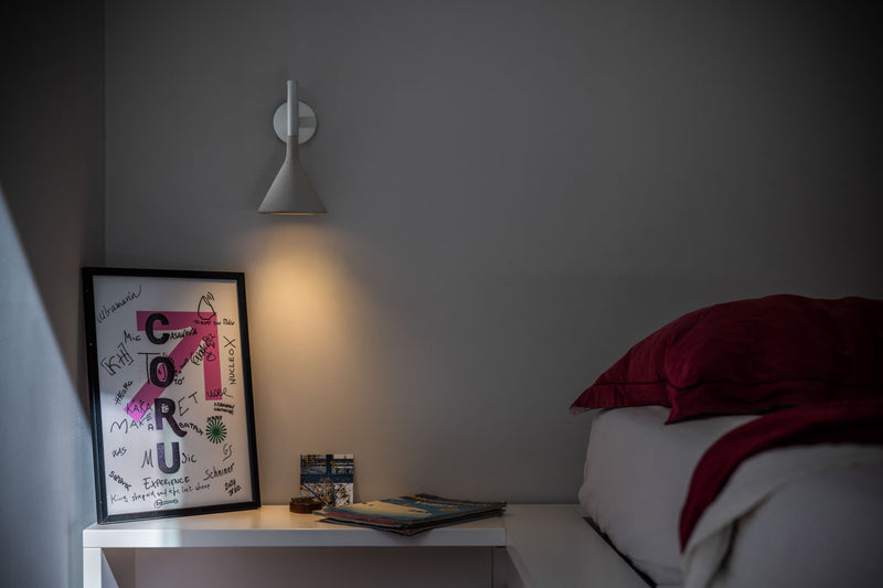 Foscarini Aplomb Mini vegglampe over nattbord på soverom