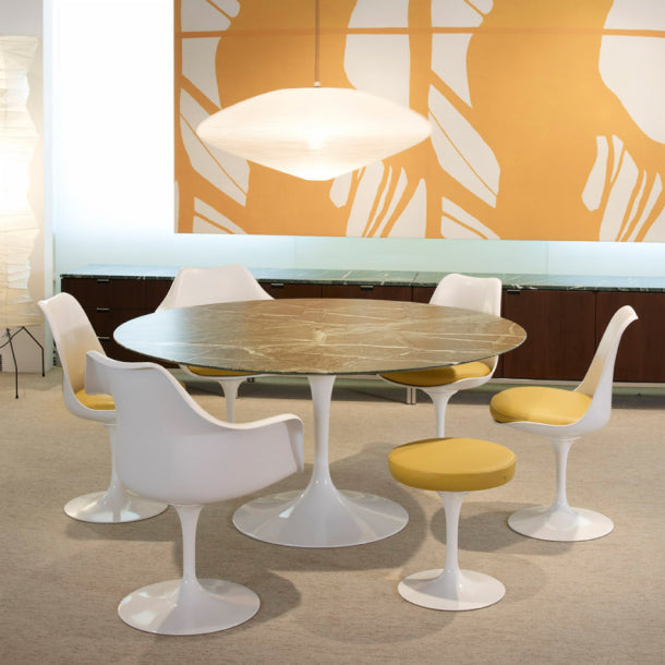 Saarinen Tulip-stoler med gule trekk ved et ovalt Saarinen-bord