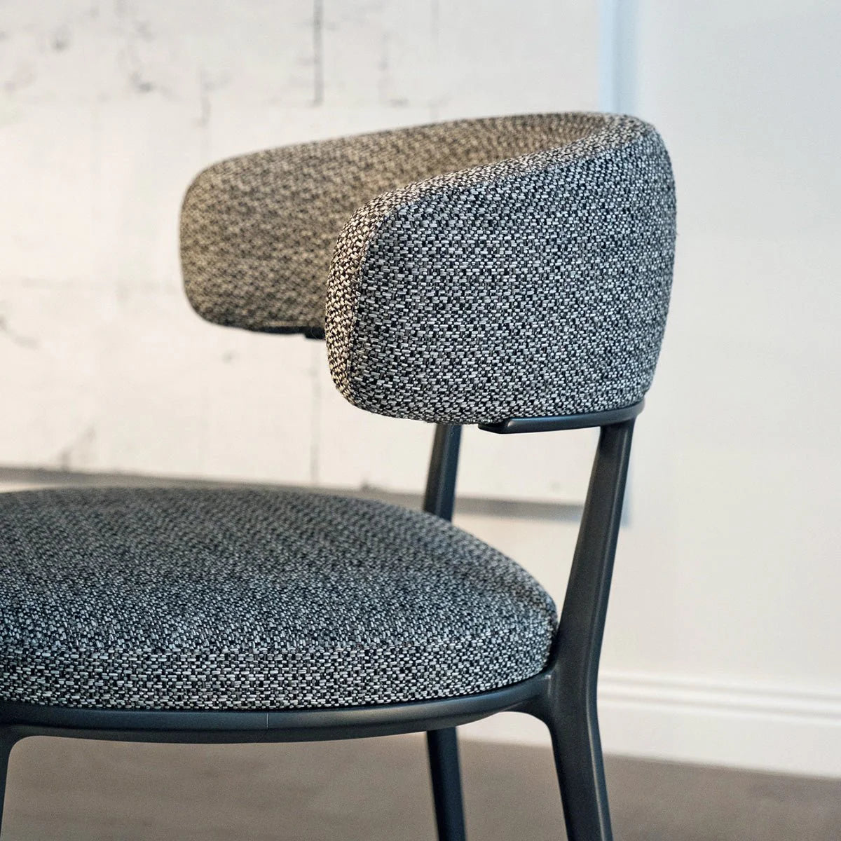 Detalj av tekstiltrukket rygg og metallramme på Maxalto Caratos spisestol