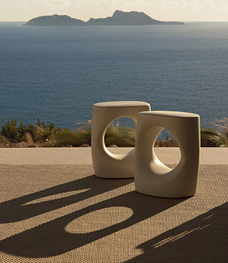 Atoll utendørs sidebord i lys kremfarget keramikk med organisk morsom form. Sidebordet er fra Italienske Poliform og designet av Emmanuel Gallina