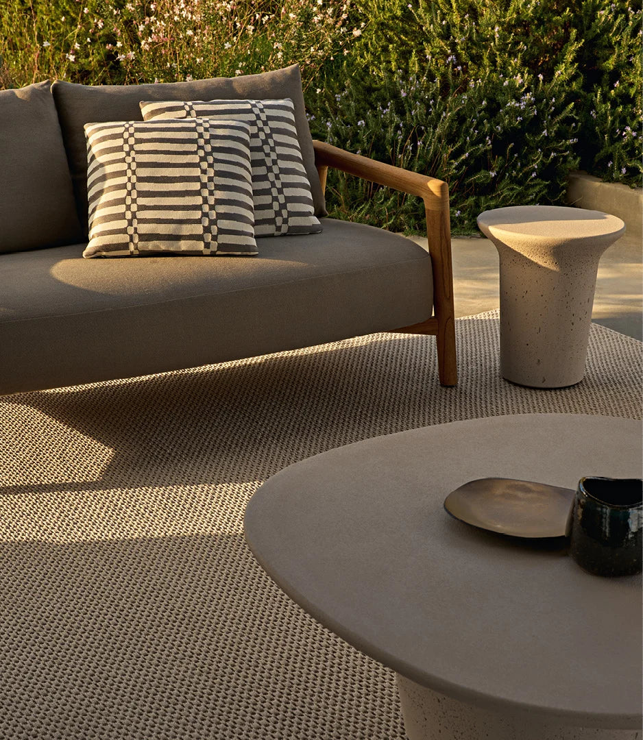 Poliform Reef Utendørs Sofabord i sement, designet av Emmanuel Gallina. Et taktilt loungebord som tåler å stå ute. 