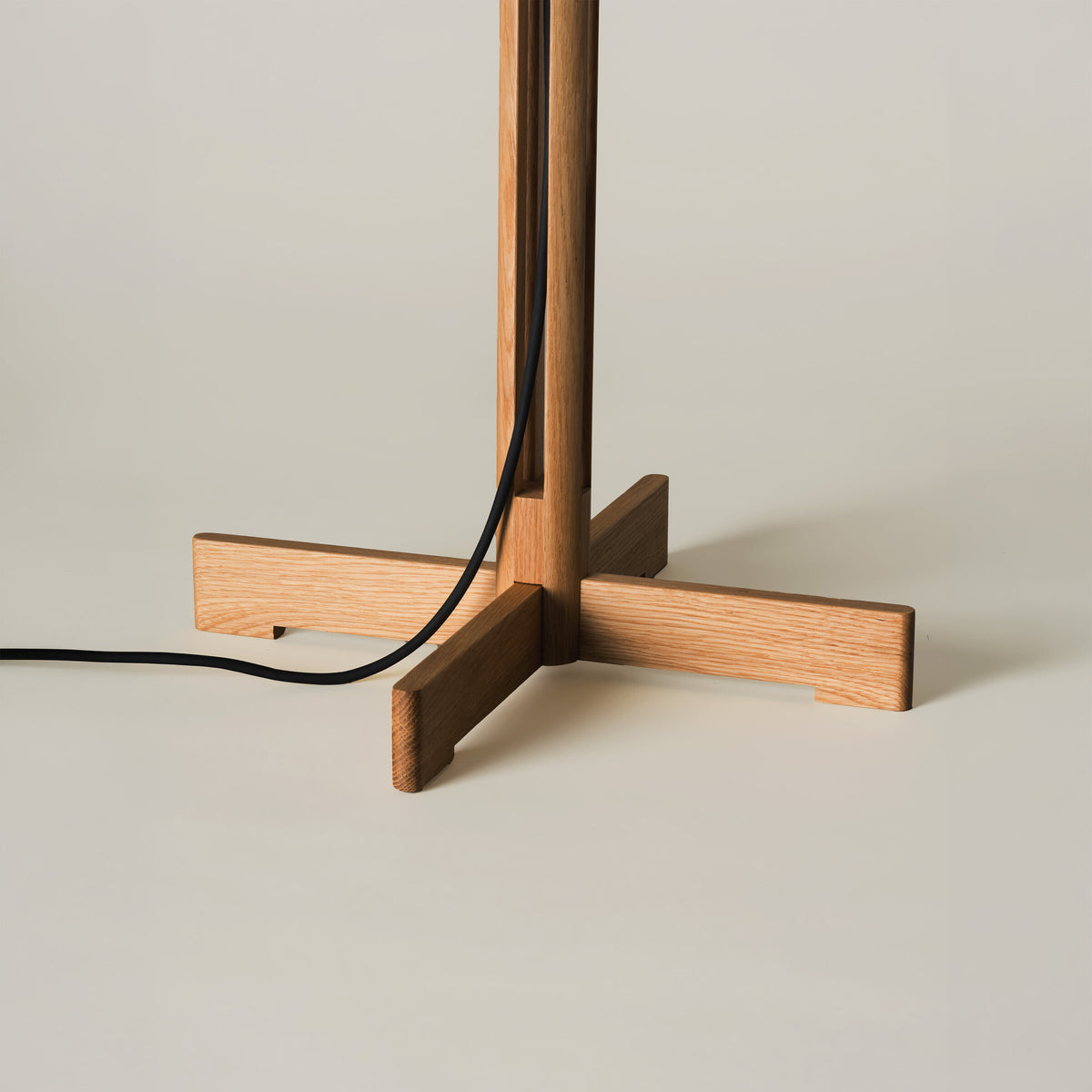 Detalj av kryssformet eikefot og ledning på FAD bordlampe