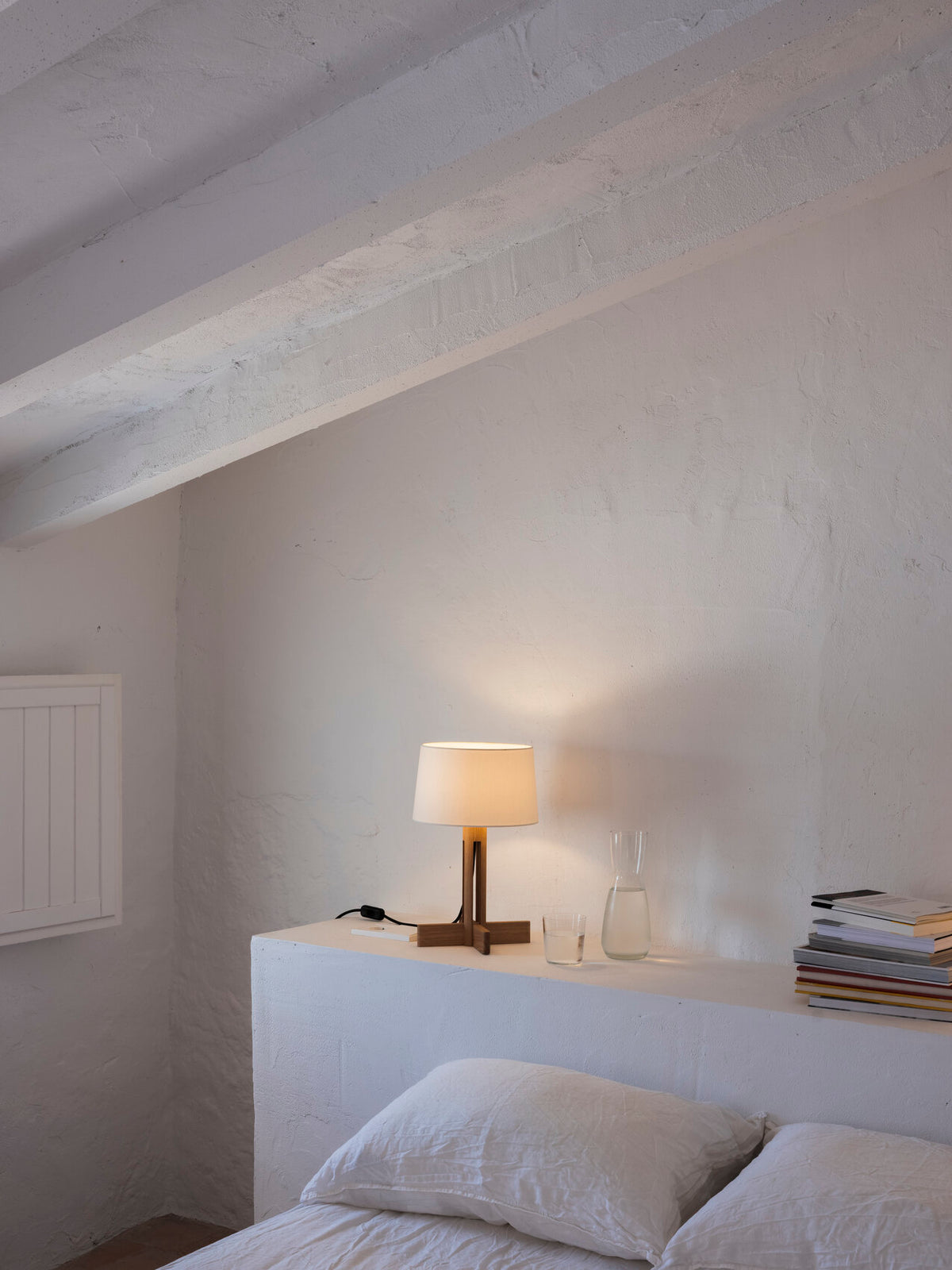 FAD Menor bordlampe på en hylle ved sengen i et lyst soverom